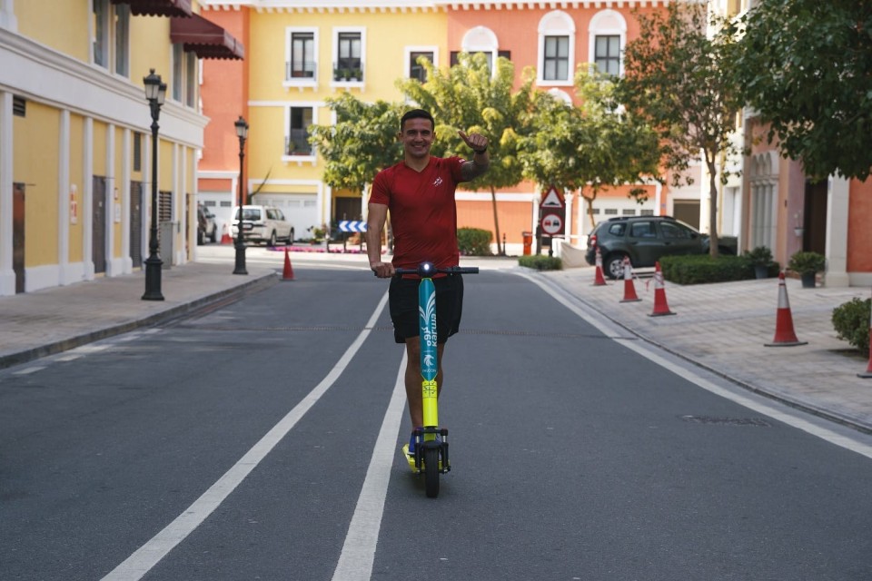 A person riding a scooter on a streetDescription automatically generated with medium confidence