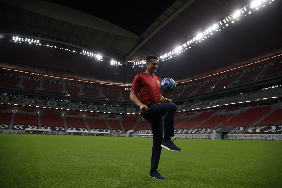 A person holding a football ballDescription automatically generated with medium confidence